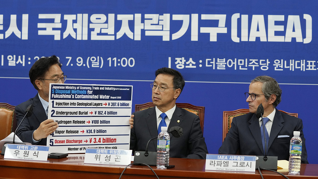 Main opposition Democratic Party lawmaker Woo Won-shik (L) shows a list of proposed disposal methods for the Fukushima contaminated water as his party lawmaker Wi Seong-gon and Rafael Mariano Grossi, director general of the International Atomic Energy Agency (R) look on during a meeting with the party's lawmakers at the National Assembly in Seoul, South Korea, July 9, 2023. /CFP