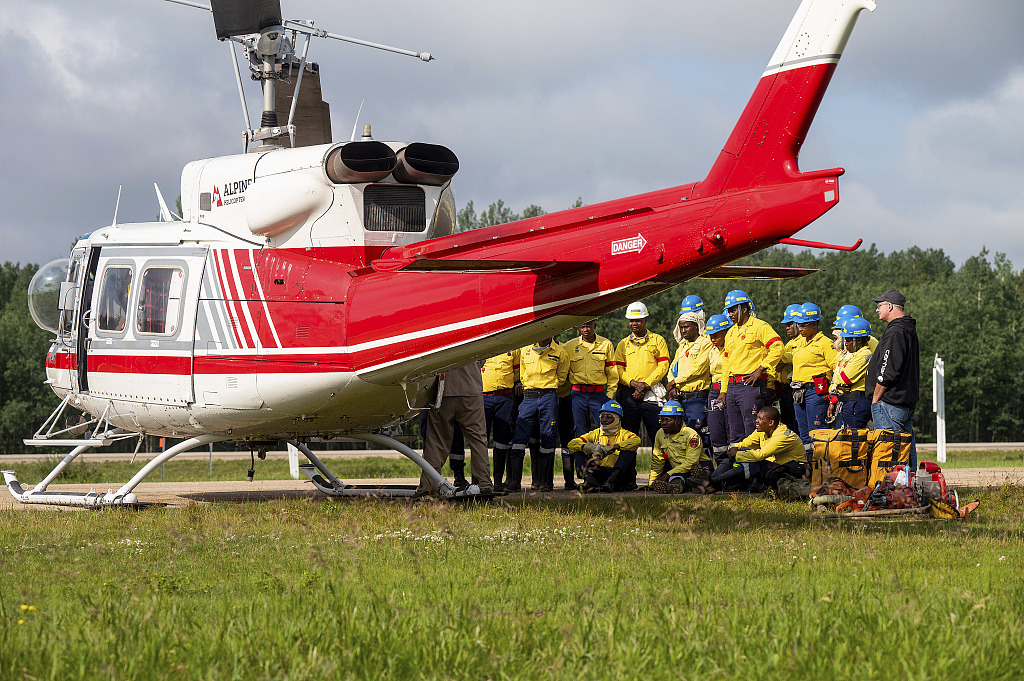South African firefighters listen during a safety briefing as they prepare to deploy a helicopter in Fox Creek, Alberta, Canada, July 4, 2023. /CFP