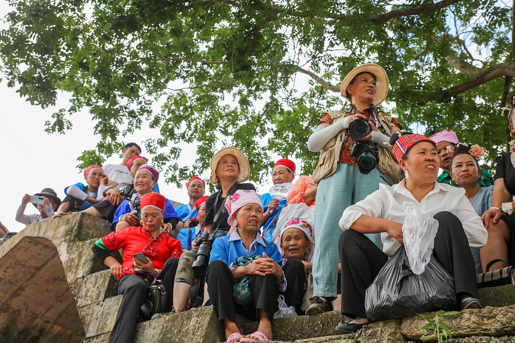This photo taken on June 22, 2022, shows Miao villagers watching the Canoe Dragon Boat races on the Qingshui River bank, southwest China's Guizhou Province. /CFP