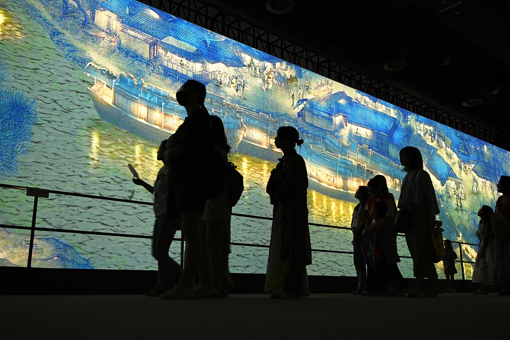 Visitors view a section of Zhang Zeduan's painting on a giant screen at the 