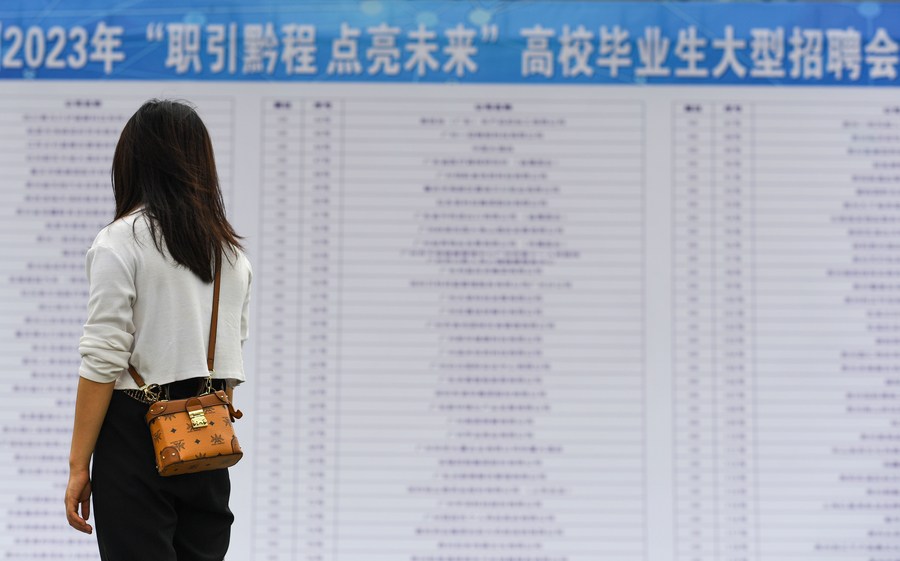 A college graduate reads recruitment information at a job fair in Qiandongnan Miao and Dong Autonomous Prefecture, southwest China's Guizhou Province, June 30, 2023. /Xinhua