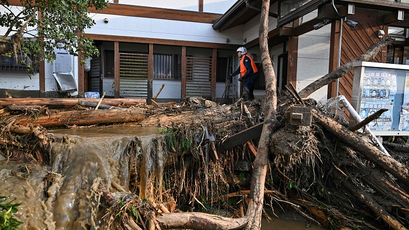 A man checks a house on a property damaged from flooding in the city of Kurume, Fukuoka prefecture, Japan, July 10, 2023. /CFP