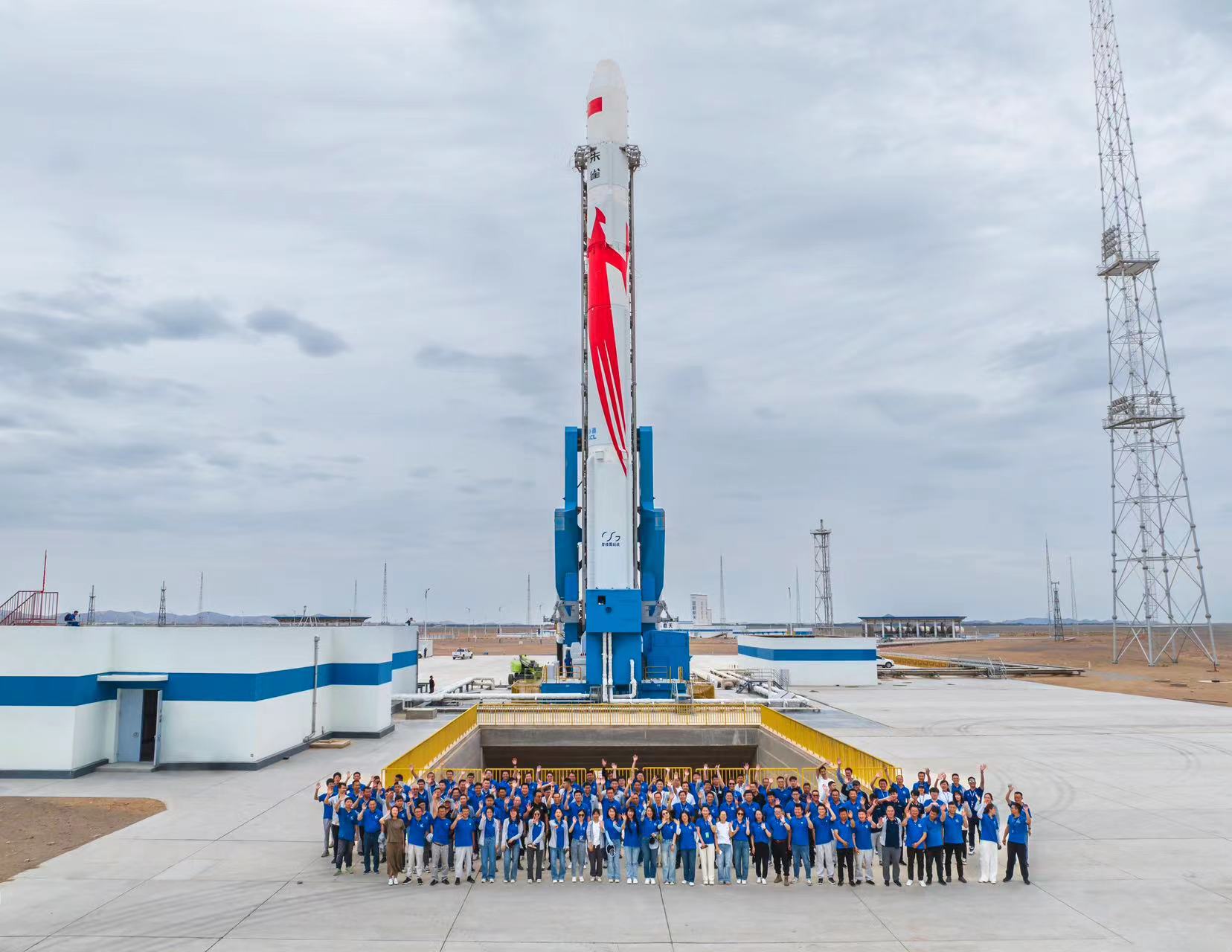 Staff members pose for a group photo before China launched Zhuque-2 Y-2 rocket from the Jiuquan Satellite Launch Center in northwest China's Gobi Desert, July 12, 2023. /LandSpace