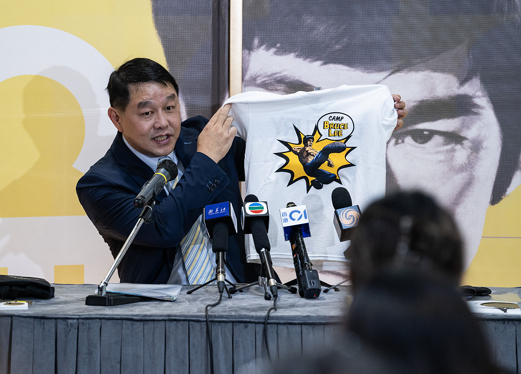 Museum director Brian Lam Kwok-fai shows a T-shirt printed with the figure of movie star Bruce Lee at the Hong Kong Heritage Museum on July 11, 2023, ahead of the opening of the exhibition 