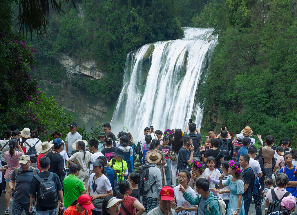 Tourists admire the majestic roar of the Huangguoshu Waterfall in Anshun, Guizhou on July 3, 2023. /CFP