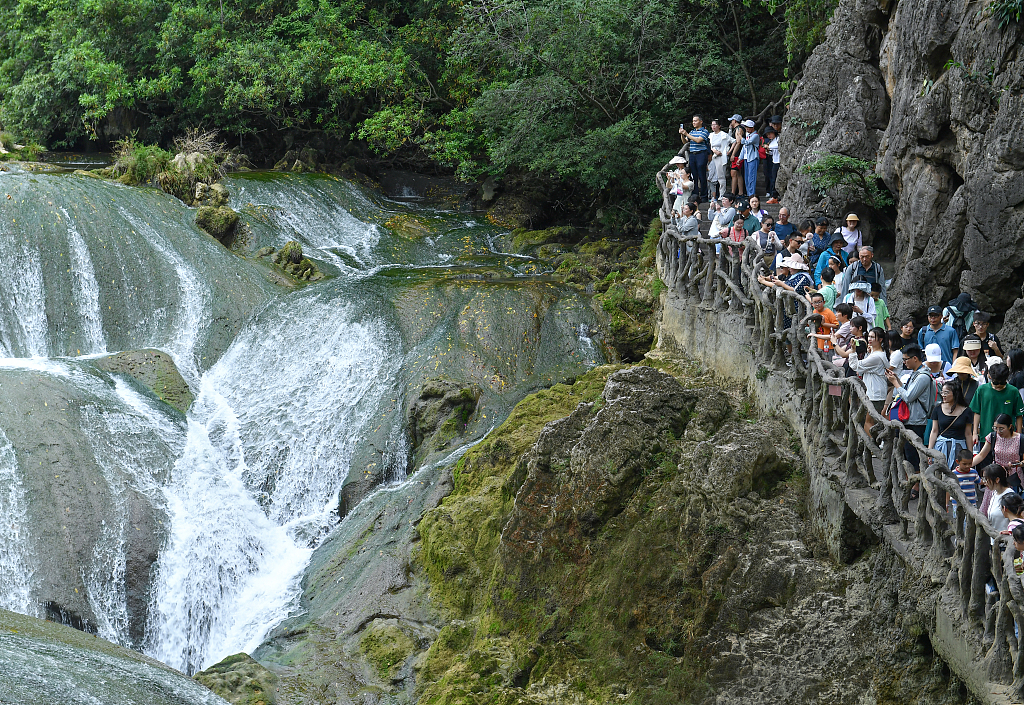 Tourists admire the majestic roar of the Huangguoshu Waterfall in Anshun, Guizhou on July 3, 2023. /CFP