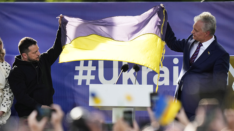 Ukraine's President Volodymyr Zelenskyy (L) and Lithuania's President Gitanas Nauseda, hold up a Ukrainian flag as they address the crowd during an event on the sidelines of a NATO summit in Vilnius, Lithuania, July 11, 2023. /CFP