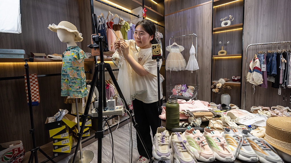 A streamer is selling children clothes via live stream, at an e-commerce base in Zhili Town, Wuxing District, Huzhou City, Zhejiang Province, June 2, 2023. /CFP