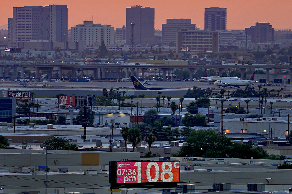 A sign displays the temperature as jets taxi at Sky Harbor International Airport at dusk in U.S., July 12, 2023. /CFP