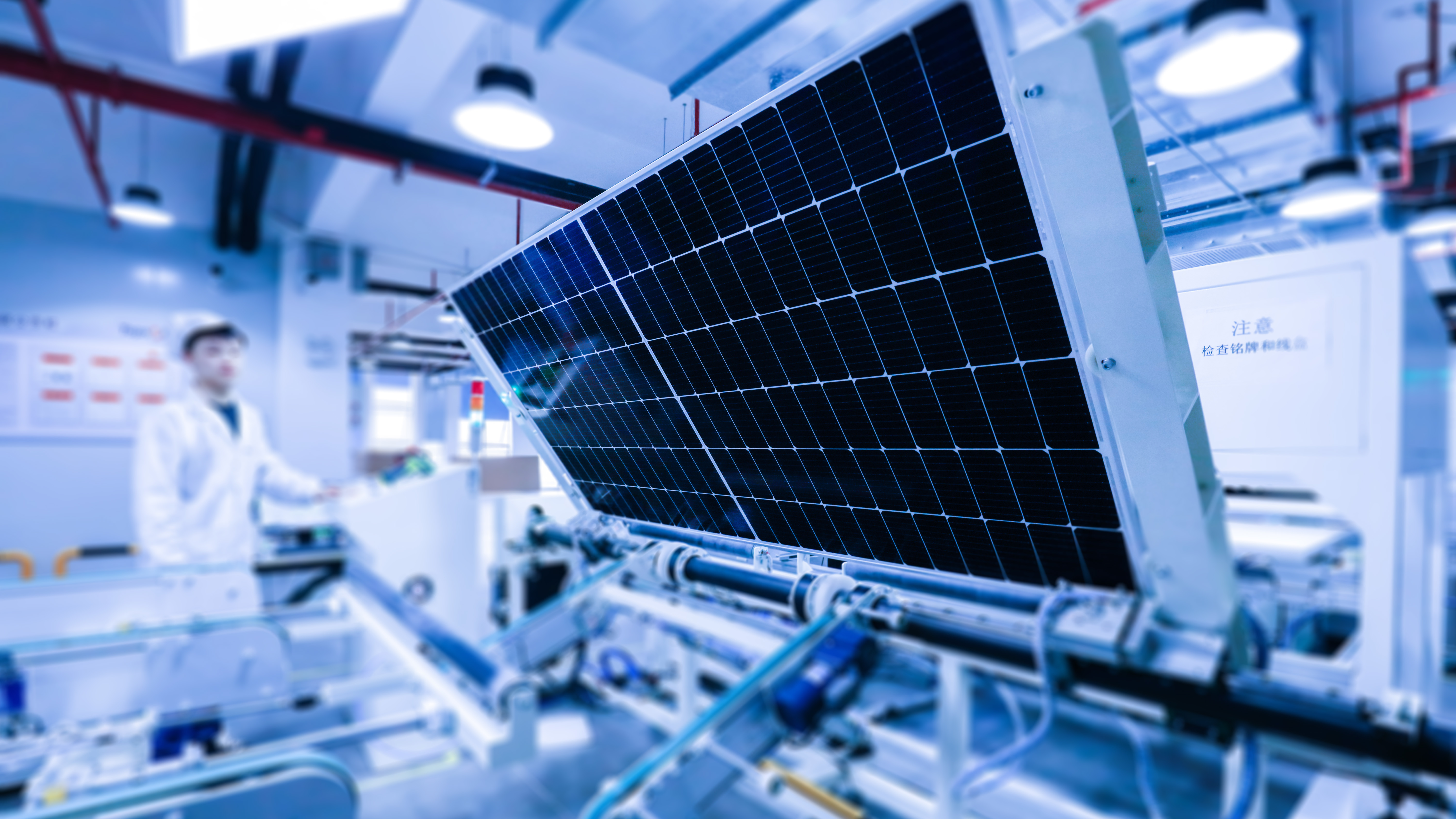 A worker operates machinery on a solar panel production line./IC Photo
