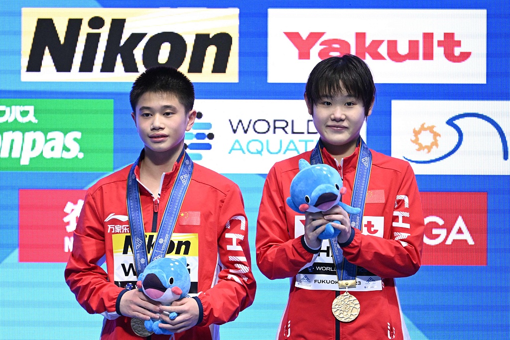Wang Feilong (L) and Zhang Jiaqi of China pose with their gold medals after winning the mixed 10-meter synchronized diving final at the World Aquatics Championships in Fukuoka, Japan, July 15, 2023. /CFP