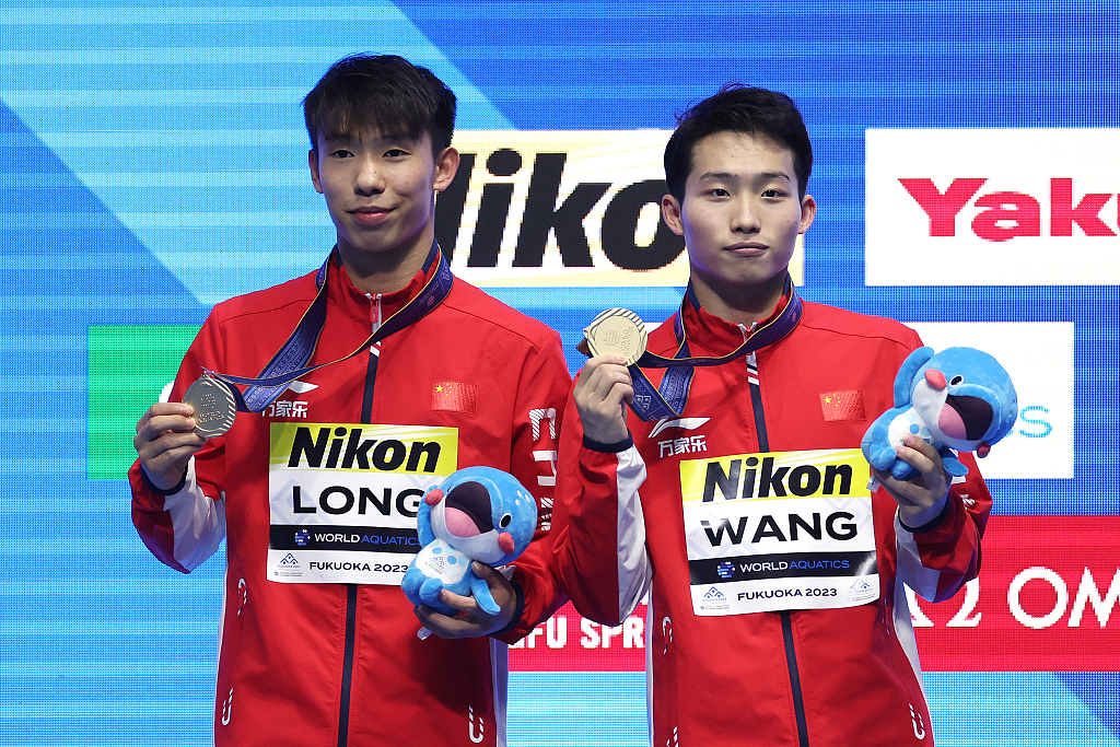 Wang Zongyuan (R) and Long Daoyi of China pose with their gold medals after winning them in the men's 3-meter synchronized diving final at the World Aquatics Championships in Fukuoka, Japan, July 15, 2023. /CFP