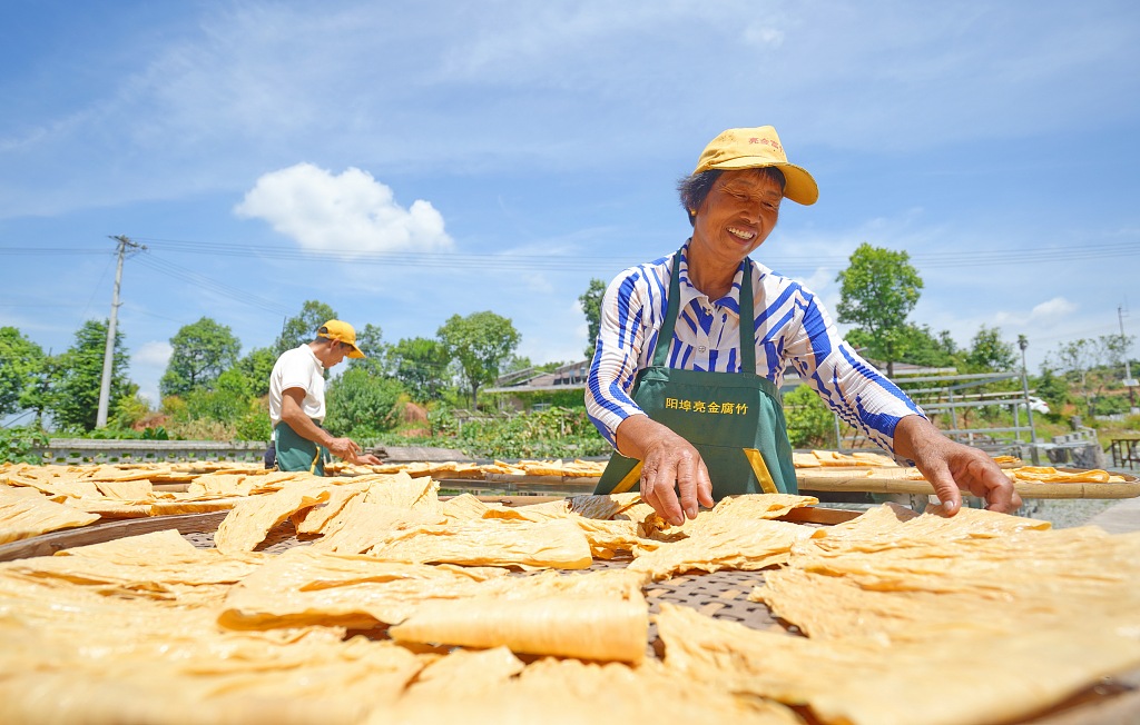 This photo taken July 14, 2023 shows residents of Ganzhou, Jiangxi Province busy sun-drying their handmade fuzhu. /CFP
