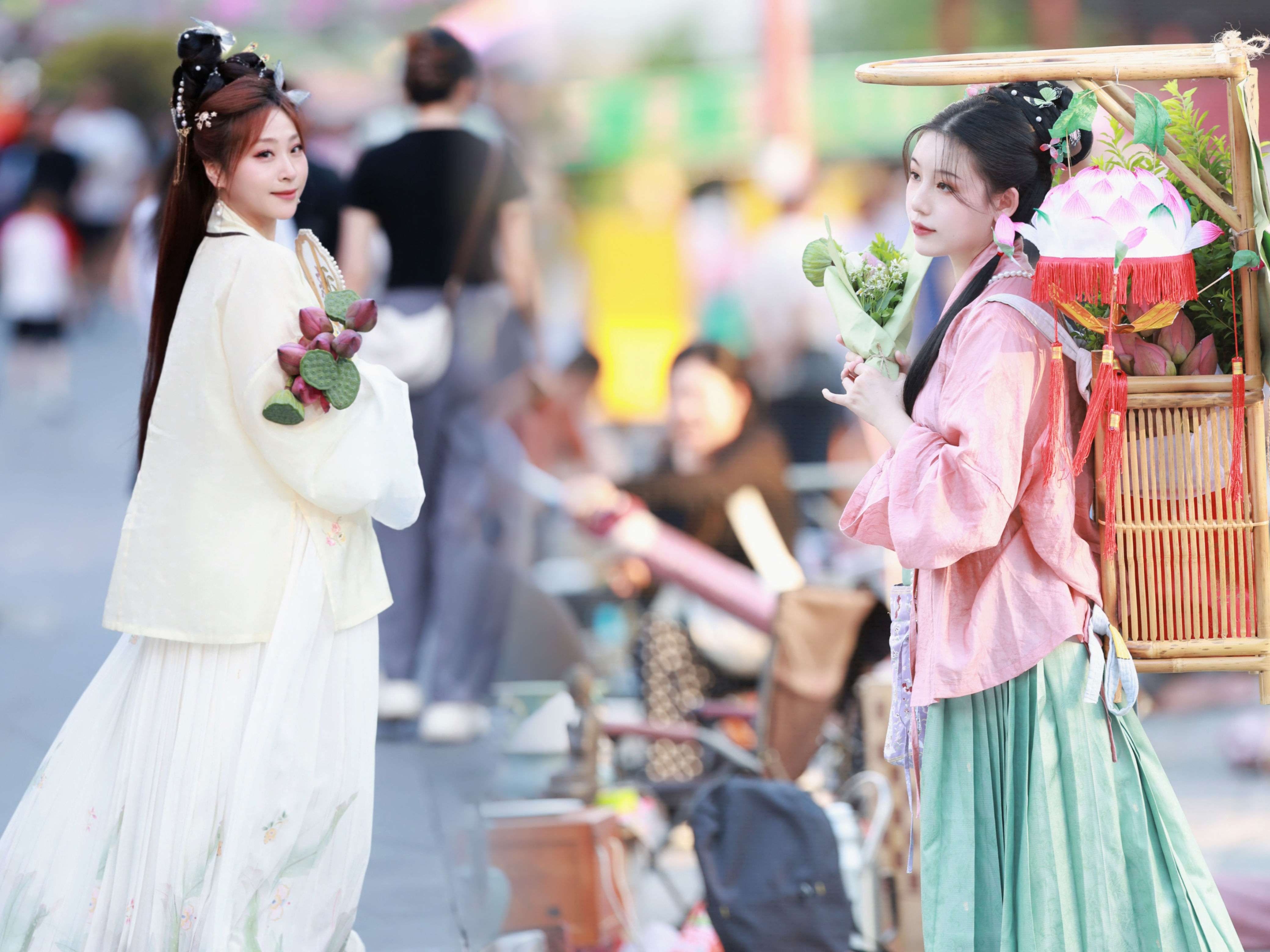 Girls dressed in hanfu pose for photos at a market in Beijing. /CGTN