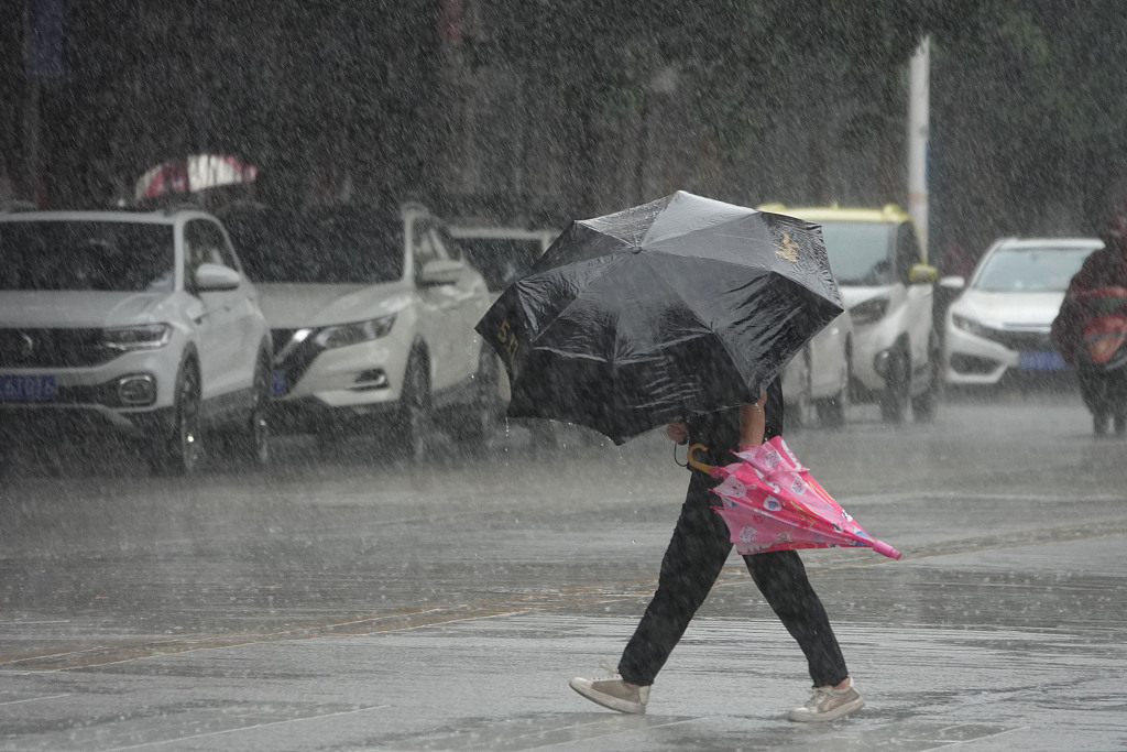 A woman walks in the heavy rain in Nanning, south China's Guangxi Zhuang Autonomous Region, July 18, 2023. /CFP