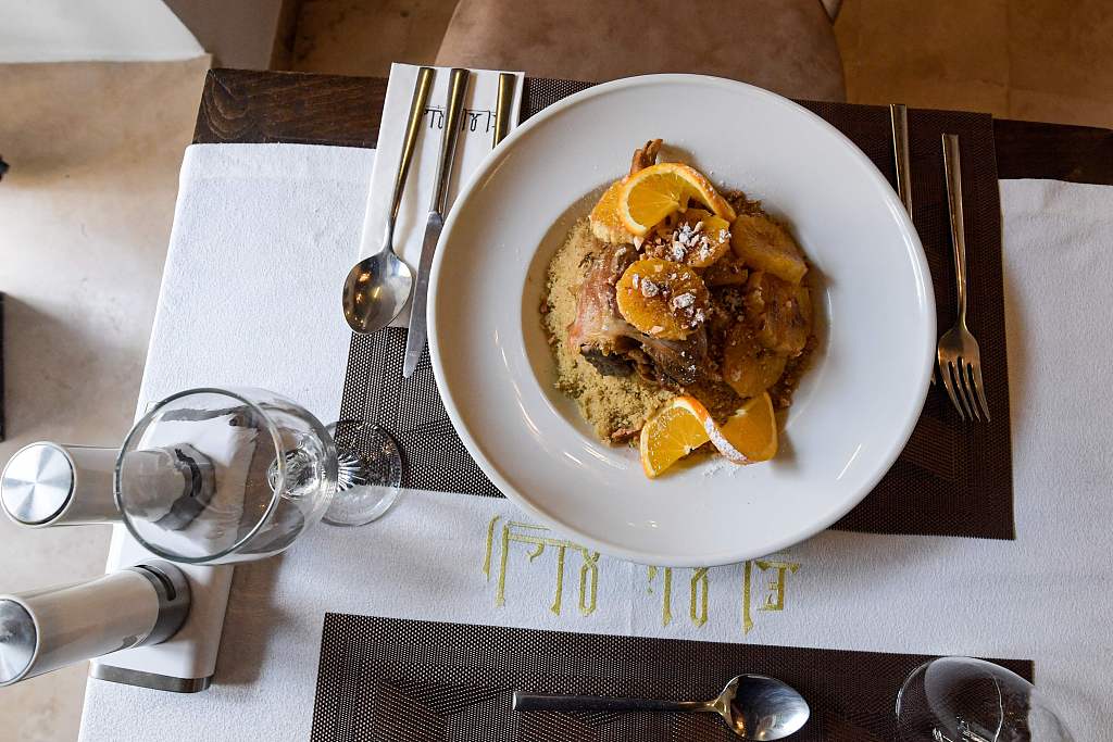 This photo taken on December 16, 2020 shows a dish of lamb and orange couscous prepared by Tunisian chef Taieb Bouhadra at a restaurant in the Medina of Tunis. /CFP