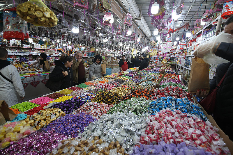 2023年1月9日，阿尔及利亚居民在当地市场购买商品。/CFP