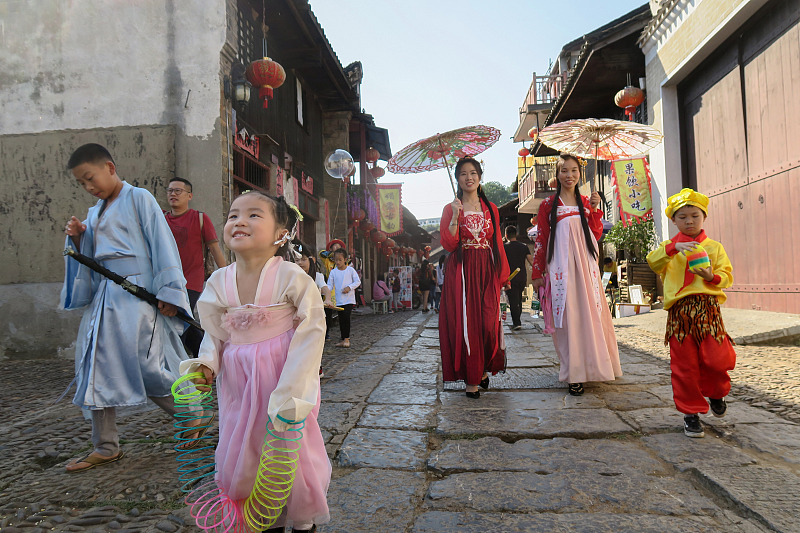 身着中国传统服装的游客在湖南省永州市柳子街上行走。  /CFP