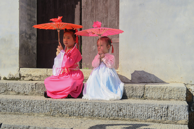 身着中国传统服装的孩子们在湖南省永州市柳子街畅游。  /CFP