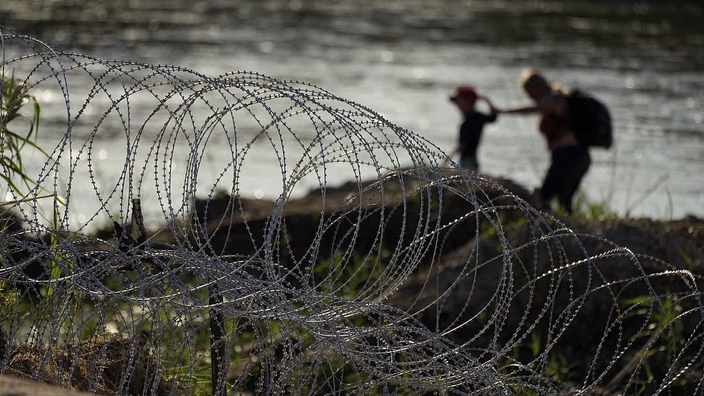 Migrants walk along concertina wire as they try to cross the Rio Grande at the Texas-U.S. border in Eagle Pass, Texas, U.S., July 6, 2023. /CFP