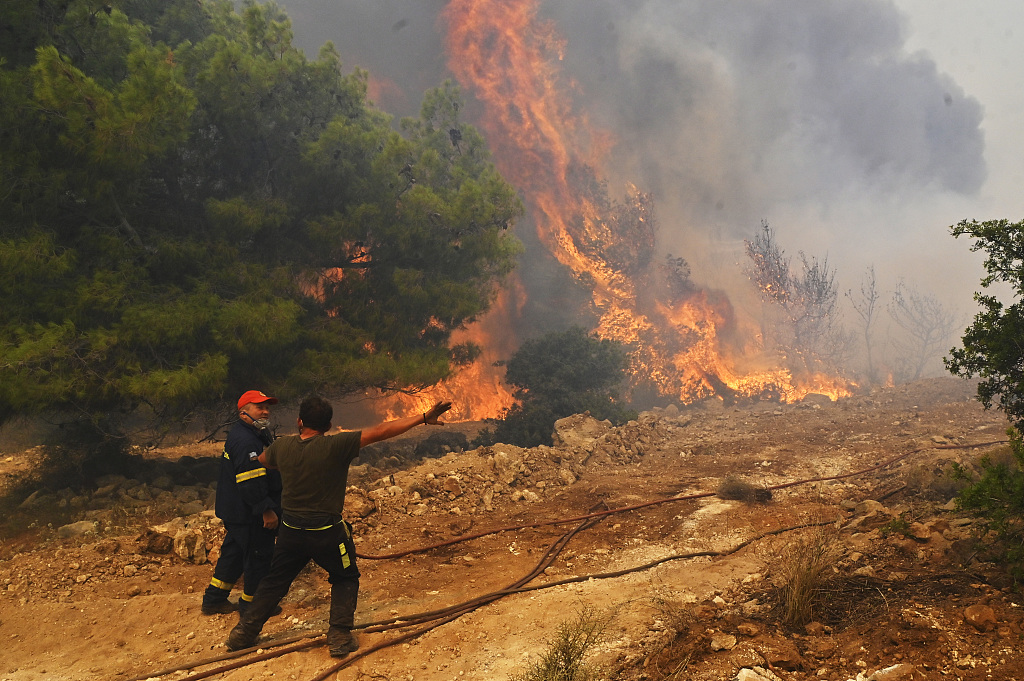 Locals help firefighters as they try to extinguish a wildfire burning near the village Vlyhada in Greece, July 19, 2023. /CFP 