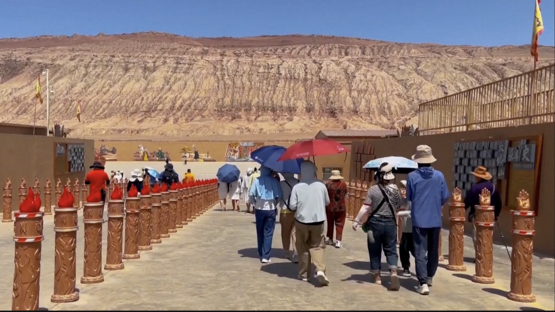景区内的游客，纷纷打伞避暑。  /中国环球电视网