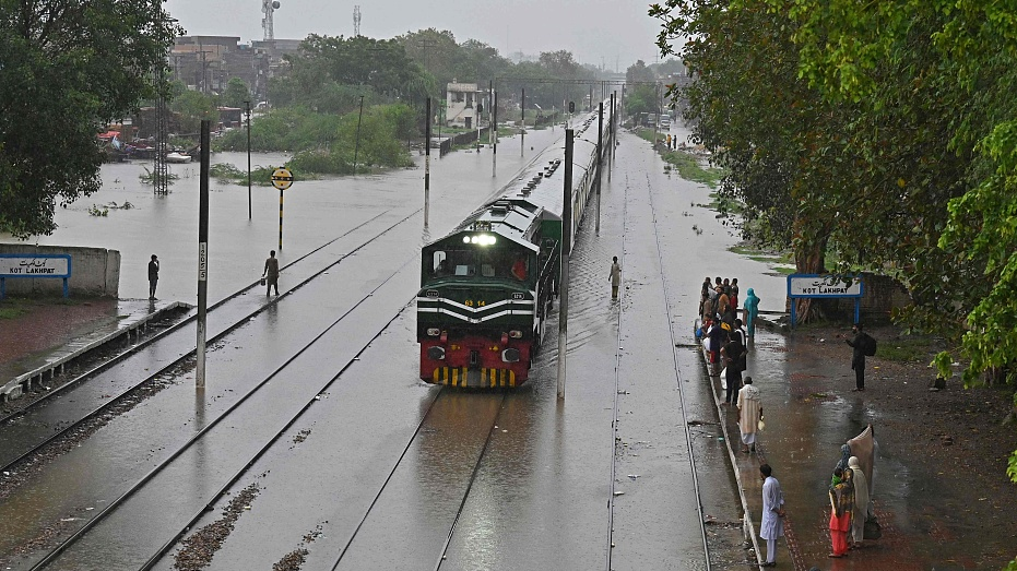 A train arrives at a flooded railway station after heavy rainfall in Lahore, Pakistan, July 5, 2023.