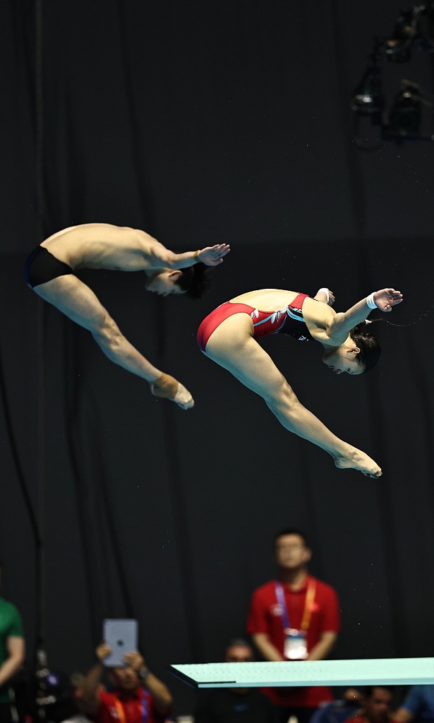2023年7月22日，在日本福冈举行的世界游泳锦标赛上，朱子峰（左）和中国选手林珊在混合3米板跳水决赛中展开角逐。/CFP