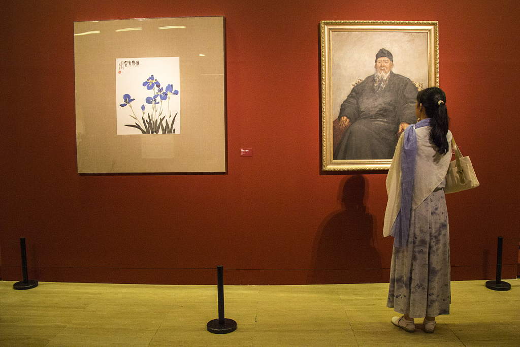 This photo taken on September 22, 2018, shows a visitor viewing artworks by Wu Zuoren and Xiao Shufang on display at the National Art Museum of China. /CFP
