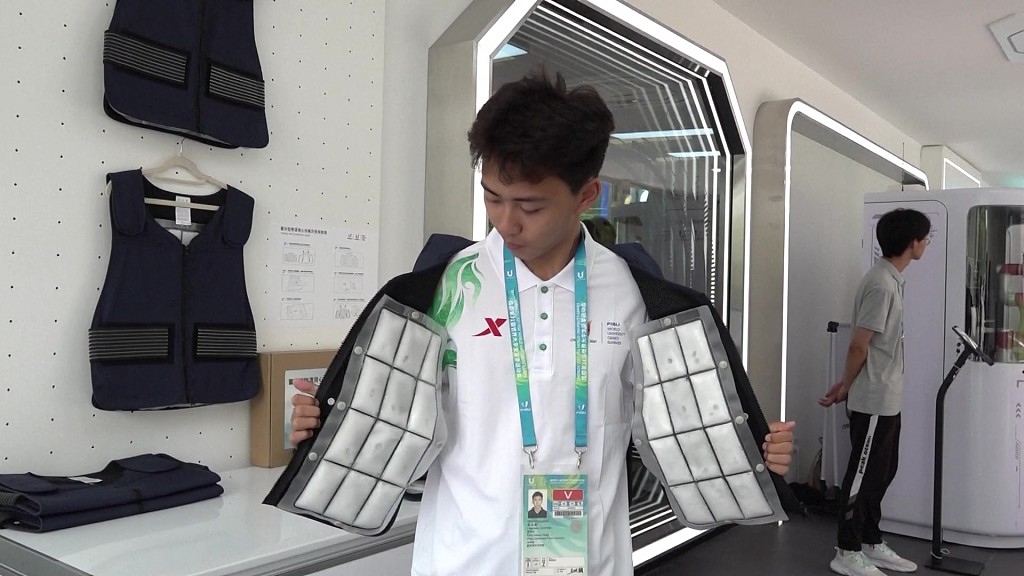 A staff member demonstrates the cooling vest in the Universiade Village. /CFP