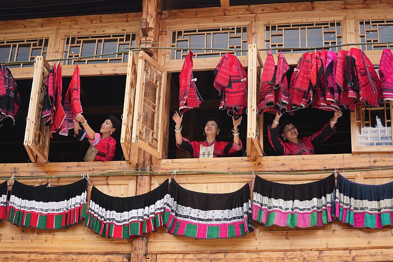 Women from the Red Yao ethnic group hang out clothes on a balcony in Longsheng County, Guilin City, Guangxi Zhuang Autonomous Region. /CFP