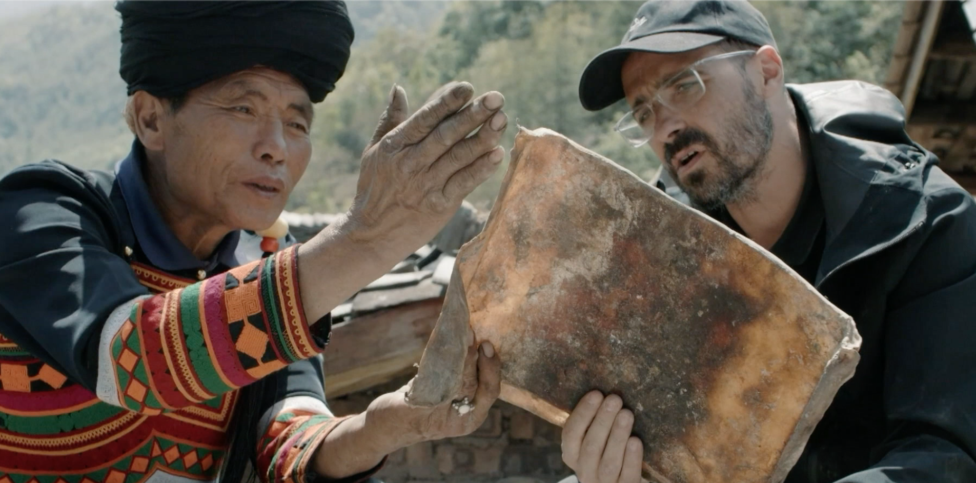 French artist Vincent Cazeneuve talks to a lacquerware craftsman from the Yi ethnic group in Liangshan Yi Autonomous Prefecture, Sichuan Province. /CGTN