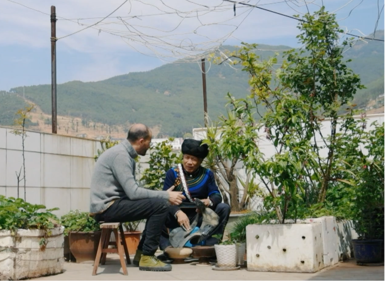 French artist Vincent Cazeneuve talks to a lacquerware craftsman from the Yi ethnic group in Liangshan Yi Autonomous Prefecture, Sichuan Province. /CGTN