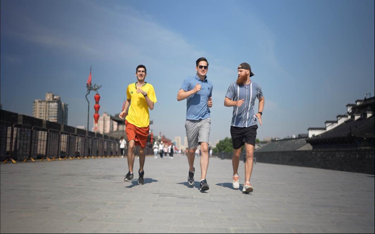 从左到右：来自俄罗斯的 Nick Gu、来自巴西的 Samuel 和来自英国的 David Geary 沿着中国西北部陕西省西安市的古城墙慢跑。  /CMG 