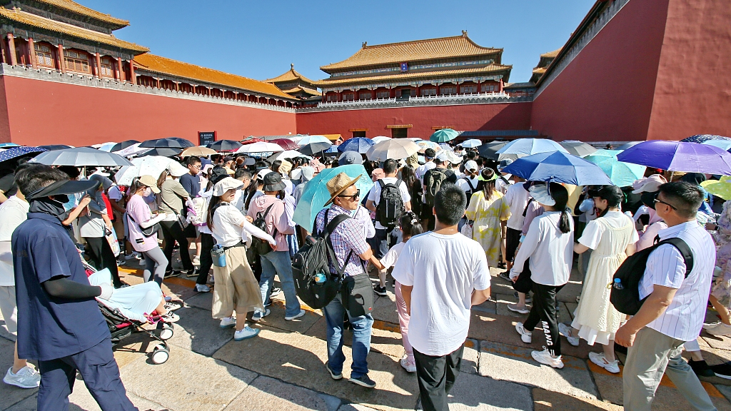 Tourists carry sun umbrellas when visiting the Forbidden City amid the heatwave in Beijing, capital of China, June 21, 2023. /CFP
