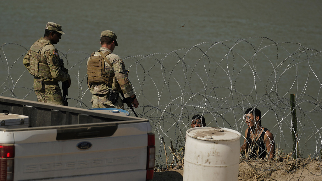 Guardsmen talk with migrants trying to cross the Rio Grande from Mexico into the U.S. near in Eagle Pass, Texas, U.S., July 11, 2023. /CFP
