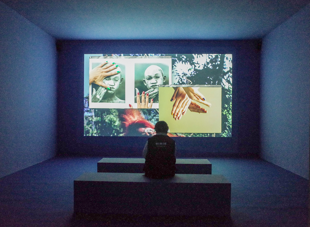 A visitor watches a moving-image work at the Red Brick Art Museum in Beijing on April 29, 2022. /CFP