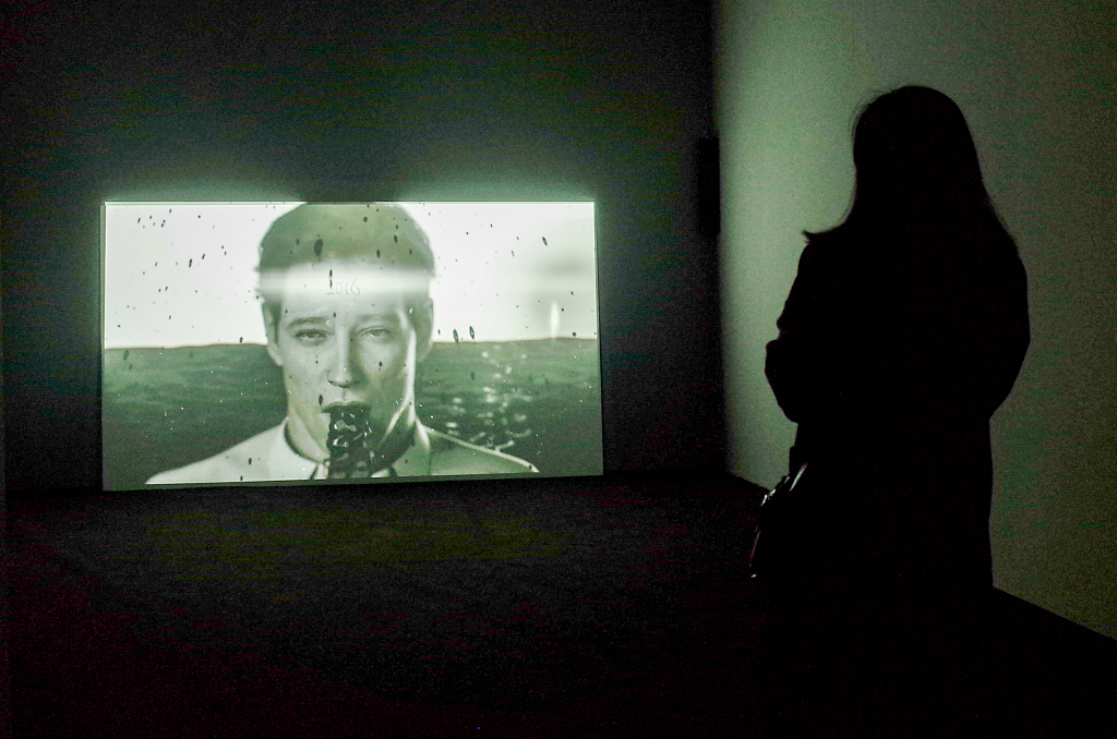 A visitor watches a moving-image work at the Red Brick Art Museum in Beijing on April 29, 2022. /CFP