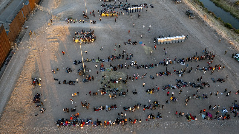 Migrants wait outside a gate in the border fence to enter into El Paso, Texas, U.S., to be processed by the Border Patrol, May 11, 2023. /CFP