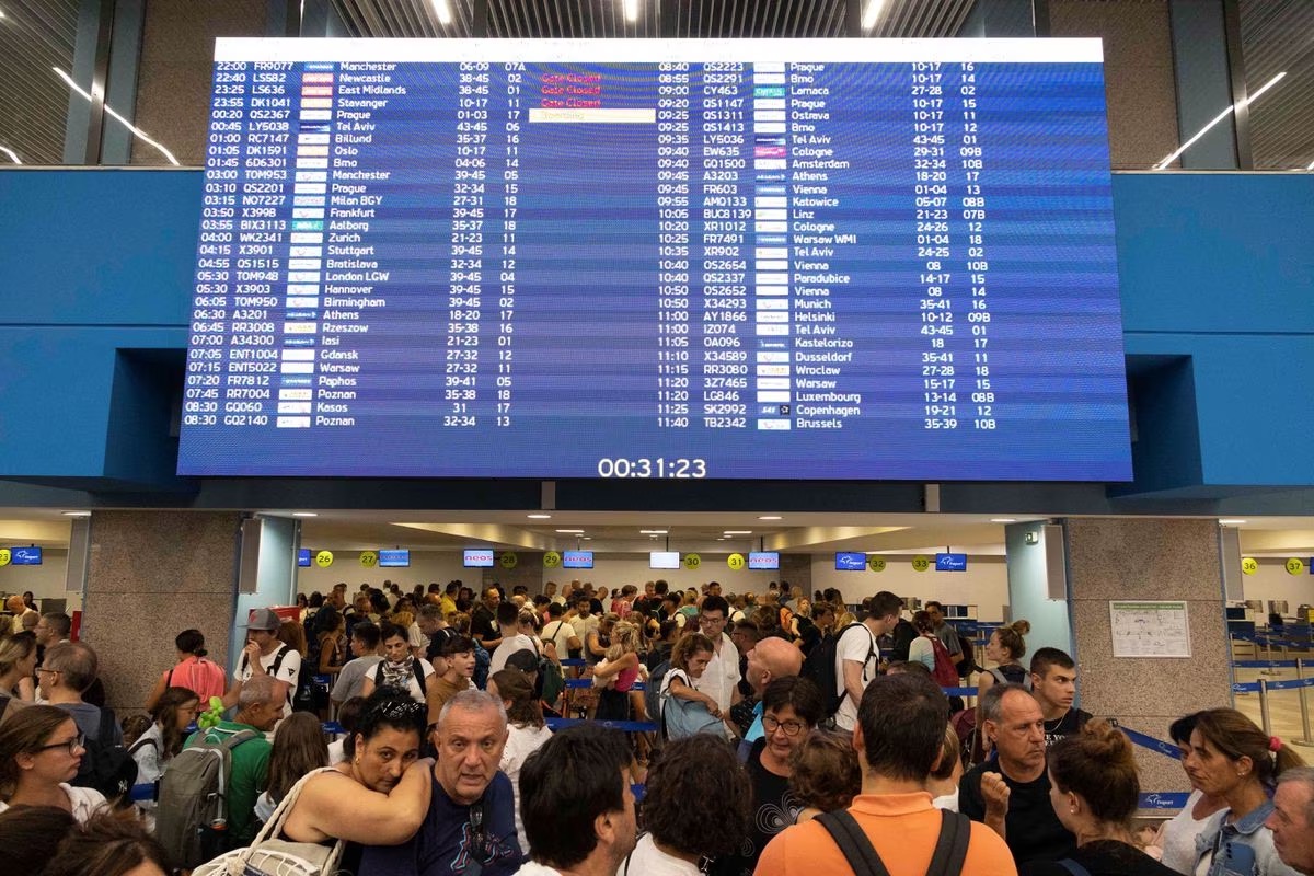 Tourists line up at check-in counters as they wait for departing planes at the airport, after being evacuated following a wildfire on the island of Rhodes, Greece, July 24. /Reuters