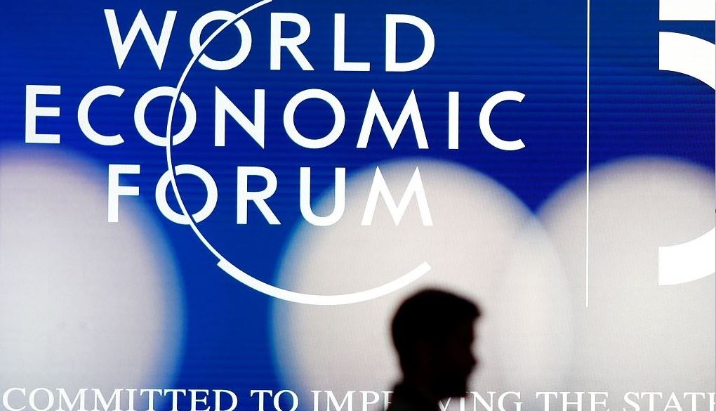 A man's silhouette in front of the World Economic Forum logo in Davos, Switzerland, January 19, 2020. /Markus Schreiber