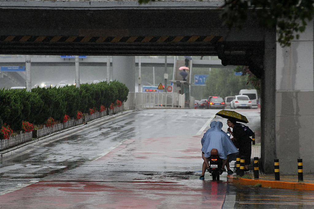 Riders in raincoats ask for directions in Beijing July 30, 2023. /CFP