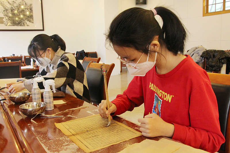 Students practice restoration skills at the Shandong Library in Jinan City, Shandong Province, February 1, 2023. /CFP