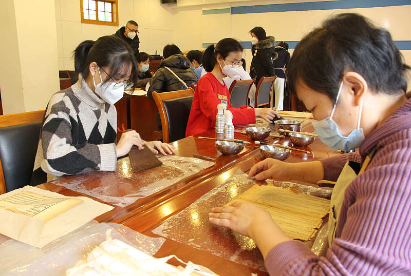 Students participate in an archaeology themed activity at the Shandong Library in Jinan City, Shandong Province, February 1, 2023. /CFP