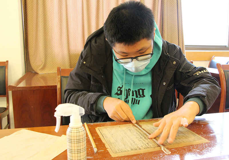 A student practices restoration skills at the Shandong Library in Jinan City, Shandong Province, February 1, 2023. /CFP