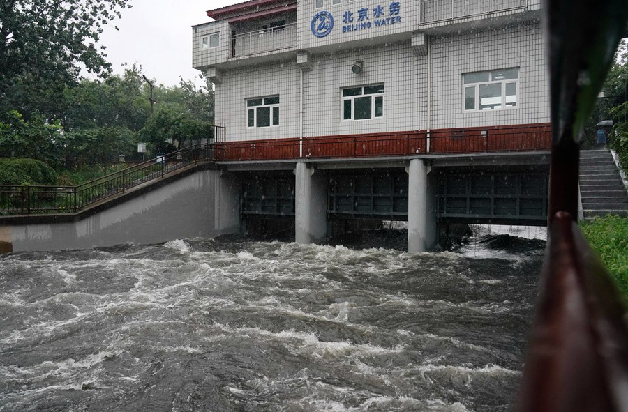 The rain water passes through a floodgate on Liangshui River in Beijing, July 30, 2023. /Xinhua