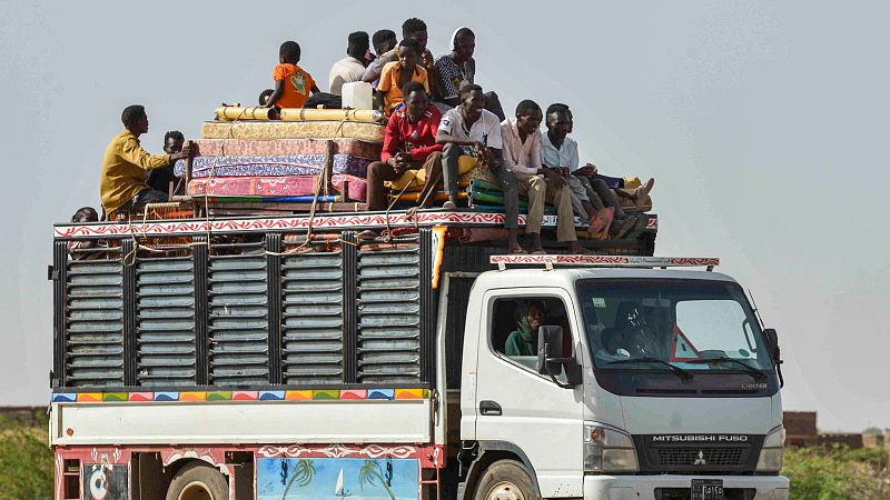 People ride with furniture and other items atop a truck moving along a road in Kamlin, about 80 kilometers southeast of Khartoum, Sudan, June 22, 2023. /CFP