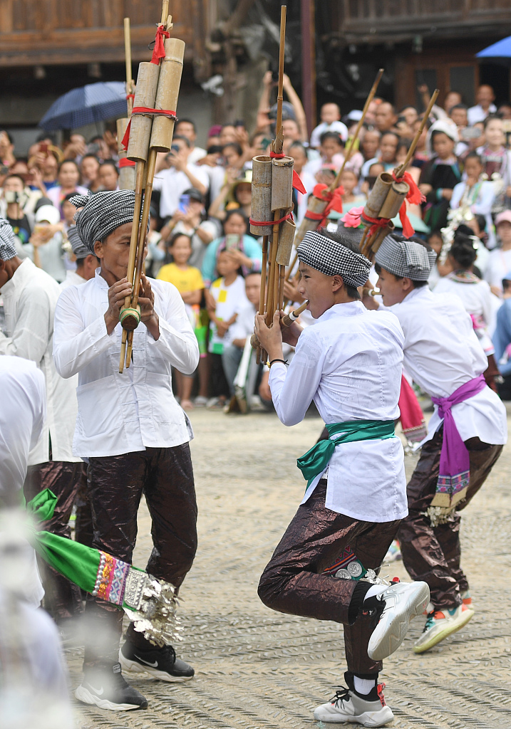 Men play the lusheng while dancing during the han tian jie festival at Huanggang Village, Liping County, southwest China's Guizhou Province, on July 13, 2022. /CFP