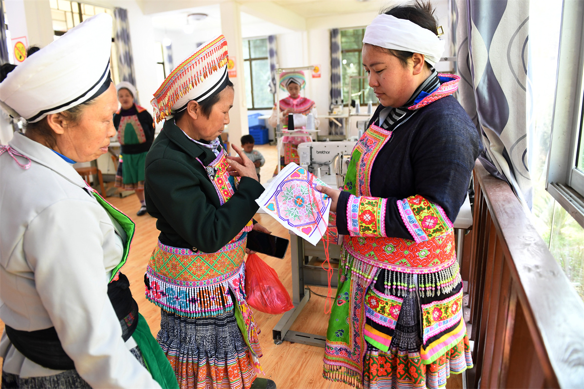 Miao women make embroidery products at a studio at Longgang Village, Huairen City, southwest China's Guizhou Province, March 14, 2023. /CNSPHOTO