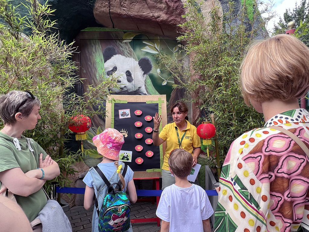 Zookeeper introduces giant pandas' living habits to kids at the Moscow Zoo in Russia, July 30, 2023. /CFP